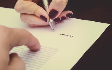 Hands of two people signed the document